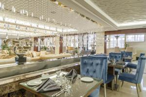 安曼Harir Palace Hotel的一间设有蓝色桌椅的餐厅和一间酒吧