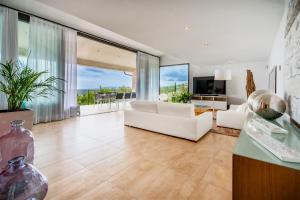 马略卡岛帕尔马Villa bonita con vistas espectaculares, perfecto para familias的客厅配有白色家具和大窗户