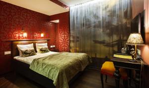 斯德哥尔摩Skanstulls Boutique Hostel的一间卧室设有红色的墙壁、一张床和一张书桌