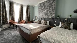 伦敦夏洛特宾馆的一间卧室设有两张床、一把椅子和窗户。