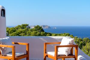 卡拉塔瑞达Oasis Living Can Nirvana - Best Sea Sunsets的一张椅子坐在一个俯瞰大海的阳台上