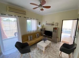 阿马利阿斯Sunny Apartment Amaliada的客厅配有沙发和两把椅子