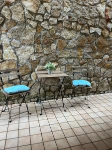 奥尔泰Casa vacanza Luna的石墙前的一张桌子和两把椅子