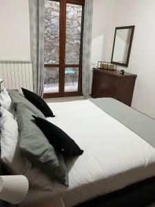 奥尔泰Casa vacanza Luna的卧室配有带枕头的床铺和窗户。