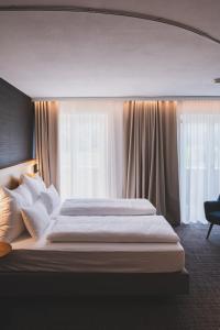 SatteinsTILL Naturhotel - Self-Check-In的一间卧室设有一张大床和一个窗户。