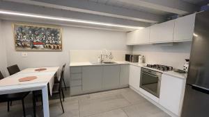 圣乔瓦尼-因马里尼亚诺I Home - Riviera Horses的厨房配有白色橱柜、桌子和水槽。