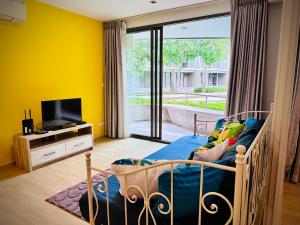 七岩班圣克兰姆公寓的一间卧室设有床铺、电视和黄色的墙壁