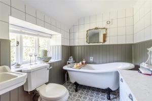 布里德波特Berehayes Holiday Cottages的带浴缸、卫生间和盥洗盆的浴室