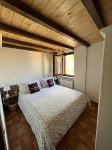 桑格罗堡Il nido的一间卧室设有一张带木制天花板的大床