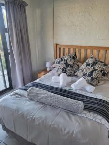 开普敦9 on Oostersee的卧室配有带枕头的床铺和窗户。