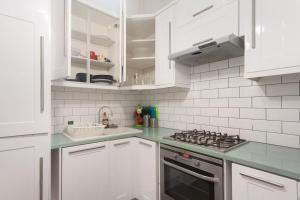 伦敦Keysan House 1的白色的厨房配有炉灶和白色橱柜。