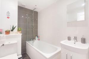 伦敦Keysan House 1的白色的浴室设有浴缸和水槽。