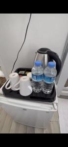 伊斯坦布尔Heybeliada Pansiyon的托盘上装有2瓶水和杯子的冰箱
