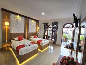 AmbaritaThyesza Hotel的酒店客房带两张床和两个窗户