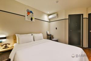 仁川市No25 Hotel Bupyeong的一间带白色大床的卧室和一间浴室