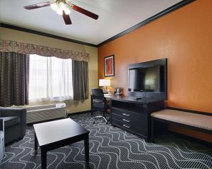 Rowlett雷哈伯德湖康福特套房酒店的酒店客房配有一张床、一张书桌和一台电视。