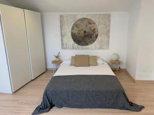 莫列鲁萨La Pau Apartaments的卧室配有一张床,墙上挂有绘画作品