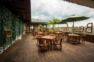 巴厘巴板Best Inn Balikpapan的一间带桌椅和遮阳伞的餐厅