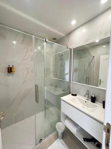 阿尔贝Le Royal Picardie的一间带玻璃淋浴和水槽的浴室