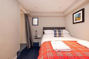 爱丁堡New Town Rooms的一间卧室配有一张带红色毯子的床