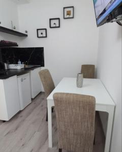 Gornja ToplicaApartmani Banja Vrujci Lux的白色的餐桌、椅子和电视