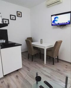 Gornja ToplicaApartmani Banja Vrujci Lux的一张带椅子的白色桌子和墙上的电视