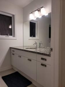 伦敦Deluxe 3 Bedroom near Hyde Park mall & Western Uni的白色的浴室设有水槽和镜子