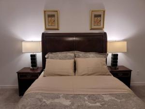 伦敦Deluxe 3 Bedroom near Hyde Park mall & Western Uni的一间卧室配有一张床、两个床头柜和两盏灯。