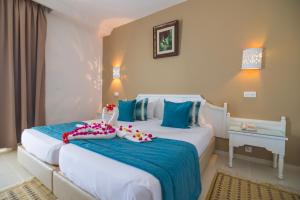 特里法TMK Marine Beach - All Inclusive Seafront resort的一间卧室配有两张蓝色和白色的床