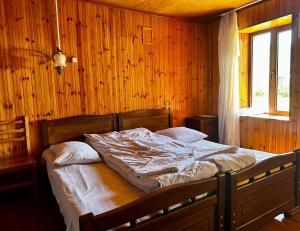 乌树故里安吉丽娜旅馆的卧室配有木墙内的一张床
