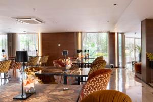 塞丹约拉·德尔·瓦勒欧洲之星瓦莱斯公园酒店的用餐室设有桌椅和窗户。