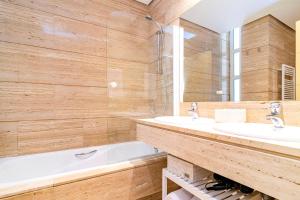 马德里Velazquez Suites的浴室配有两个盥洗盆和浴缸。