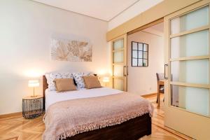 马德里Velazquez Suites的一间卧室设有一张大床和一个滑动玻璃门
