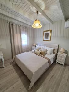 DhafnésOrnament: Infinite Nature Villa的卧室配有一张白色大床和吊灯。