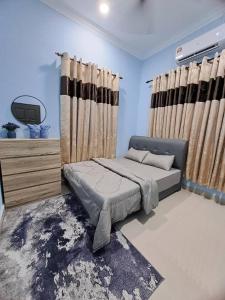 JeliHomestay Jeli - Cattleya Inn Muslim的一间卧室配有床和带窗帘的窗户