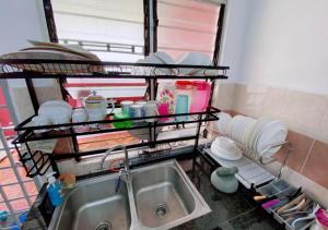 瓜拉丁加奴Homestay Murah Kuala Terengganu的厨房设有水槽和餐具架
