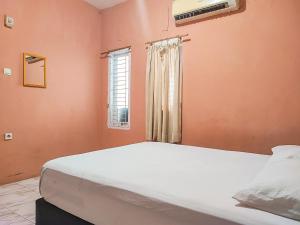 占碑市Reddoorz Syariah Near Kantor Gubernur Jambi的一间卧室设有一张大床和一个窗户。