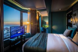 滨海绍森德赛文酒店的一间酒店客房,设有一张大床和一个大窗户