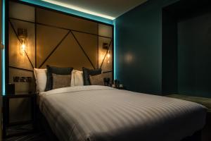 滨海绍森德赛文酒店的一间卧室配有一张大床和大床头板