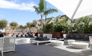 略夫雷加特河畔奥斯皮塔莱特萨博普拉萨尤罗帕酒店的一个带沙发和椅子的庭院和棕榈树