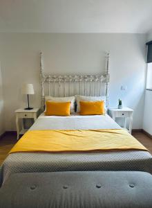 波尔图Guest house D. Filipe I的一间卧室配有一张带黄色枕头的大床