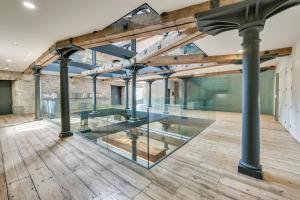 普里茅斯Luxury 2 bed Apartment in historic Royal William Yard的空房间设有玻璃墙和木地板