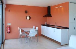 VimieiroBubulcus and Bolotas - Off Grid Nature Holiday Home的厨房配有桌椅和橙色墙壁