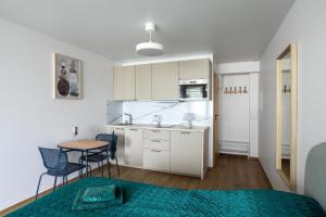 帕兰加Nauji apartamentai su šildomu baseinu, sporto sale, vaikų kambariu, work zona的一间小厨房,内设桌椅