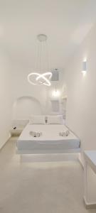 提诺斯Cozy Now的白色的客房配有一张床和吊灯