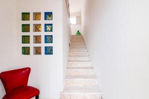 卡斯特里尼亚诺德尔卡波Appartamento Tevere的楼梯,墙上挂着红色椅子和照片