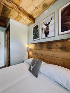 巴多尼奇亚La Maison - Il Riparo del Cervo的卧室配有一张床,墙上挂着鹿