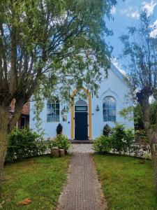 ZeerijpKerkje De Kleine Antonius的白色的房子,有蓝色的门和砖车道