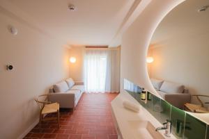 萨洛Terra Aurea Aparthotel的客房设有两张沙发和一个窗户。