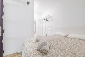 马德里Arturo Soria Apartments3的白色卧室,配有带毛巾的床